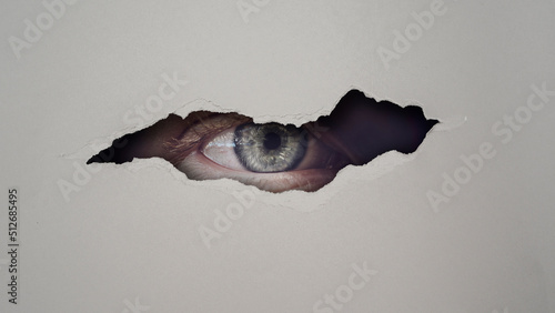 Fotografie privacy concept  with eye peeking through hole