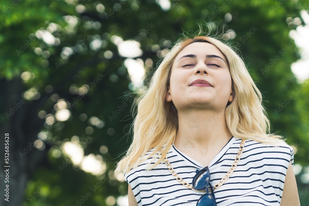 medium closeup shot of a young blond Caucasian girl enjoying the fresh air in summer. green background outdoors. High quality photo medium closeup shot of a young blond Caucasian girl enjoying the fresh air in summer. green background outdoors. High quality photo