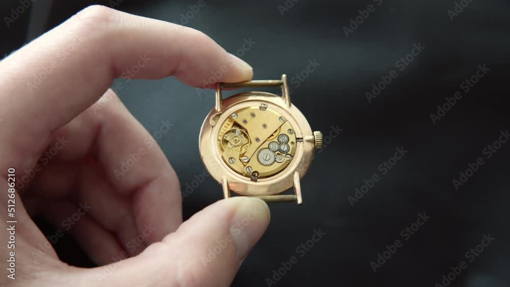 Watchmaker shows clockwork mechanism with jewels, close-up. Vintage luxury watchmakers craftmanship. Watchmaker shows clockwork mechanism with jewels, close-up. Vintage luxury watchmakers craftmanship.