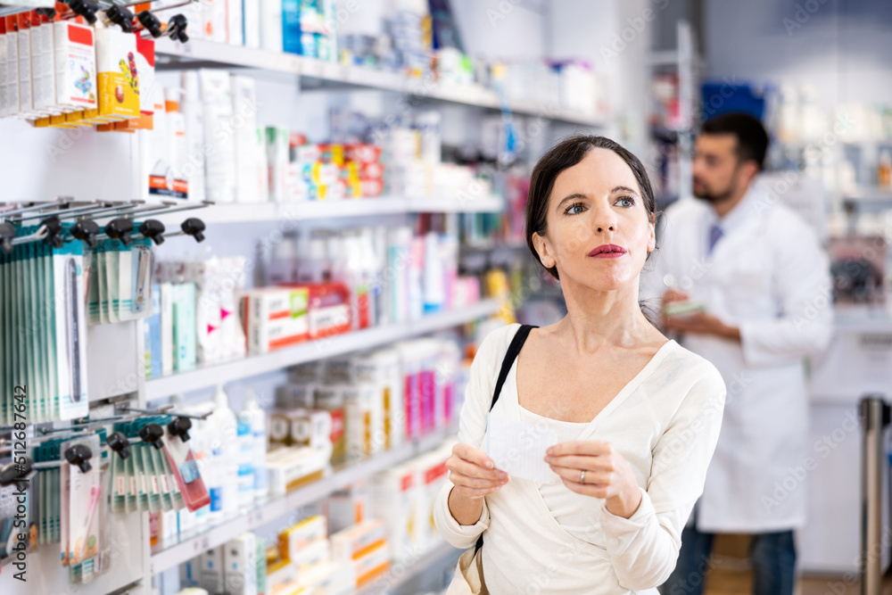 Confident young adult woman consumer holding shopping list shopping at pharmacy