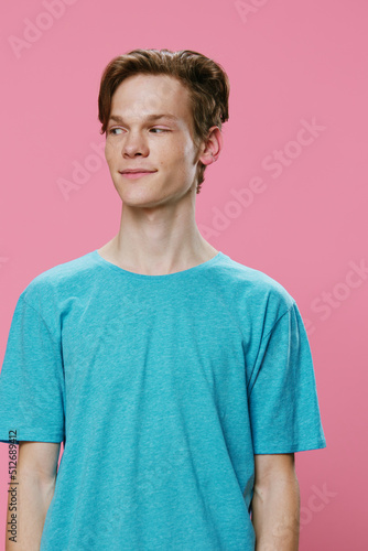 vertical portrait of a cute, nice guy in a blue t-shirt looking away