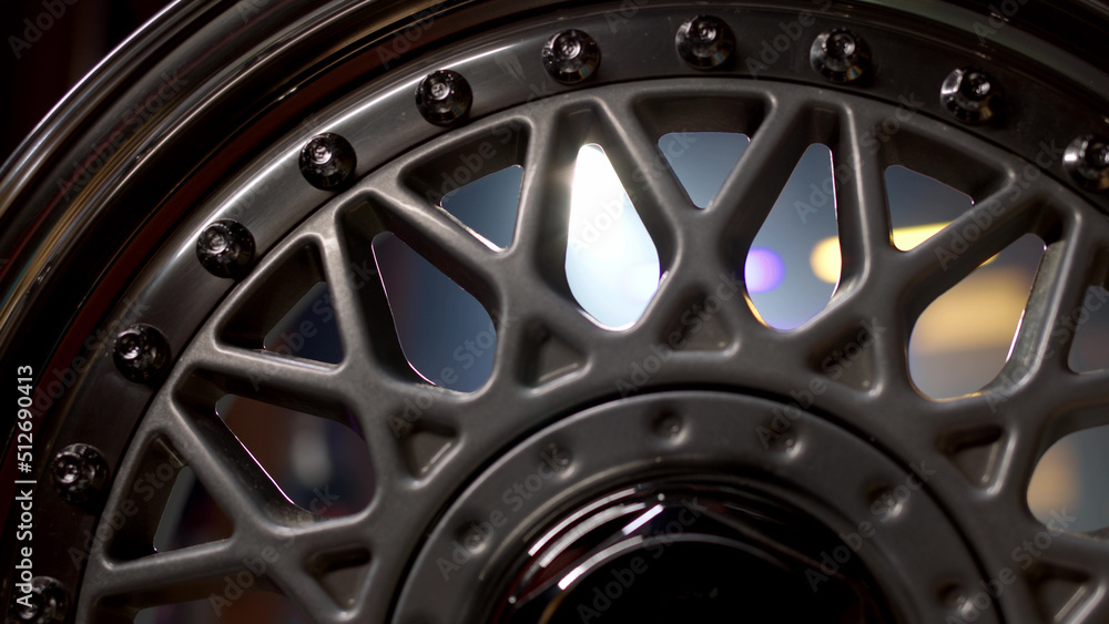 Close up view of three-piece forged silcer color wheels with classic pattern. Beautiful rims with chrome-plated shiny shelf with perfect polished bolts are spinning. Close up view of three-piece forged silcer color wheels with classic pattern. Beautiful rims with chrome-plated shiny shelf with perfect polished bolts are spinning.