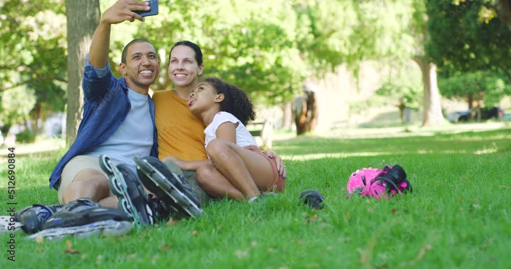 Young carefree family taking a selfie sitting in a park. Cheerful latin man taking a photo with his little daughter and wife in a garden. Playful, parents spending time with their child outside Young carefree family taking a selfie sitting in a park. Cheerful latin man taking a photo with his little daughter and wife in a garden. Playful, parents spending time with their child outside
