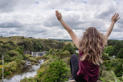 woman with raised up hands enjoying beautiful nature landscape