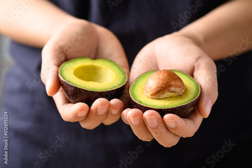 Ripe avocado fruit holding by hand ready to eating