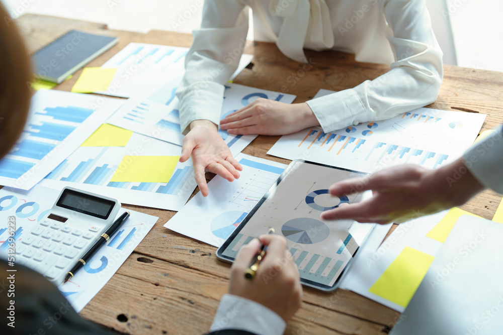 Male businesswoman pointing to tablet monitor summarizing marketing strategy with female colleagues in meeting, teamwork, investment planning Male businesswoman pointing to tablet monitor summarizing marketing strategy with female colleagues in meeting, teamwork, investment planning
