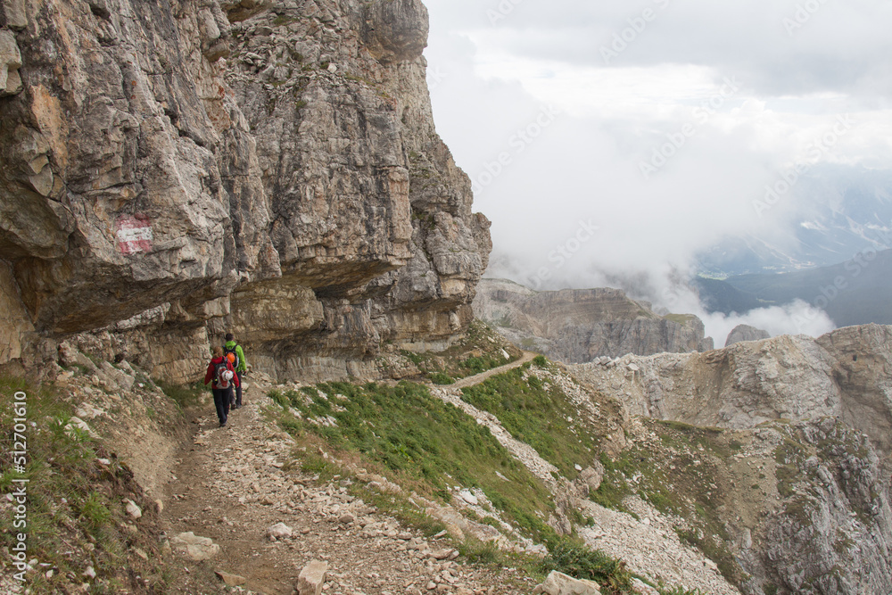 Tourists walking on a trail in mountains in a foggy day, Lagazuoi, Italian Alps. Tourists walking on a trail in mountains in a foggy day, Lagazuoi, Italian Alps.