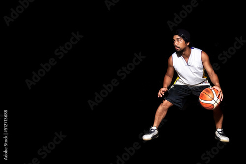 Gesture of Asian basketball player dribbling on black background. Basketball concept in Asia