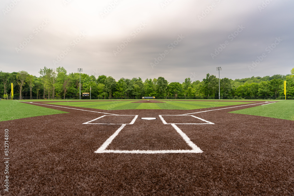 View of  high school synthetic turf baseball field looking from batters box toward the outfield.