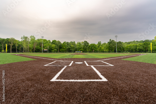 View of  high school synthetic turf baseball field looking from batters box toward the outfield.