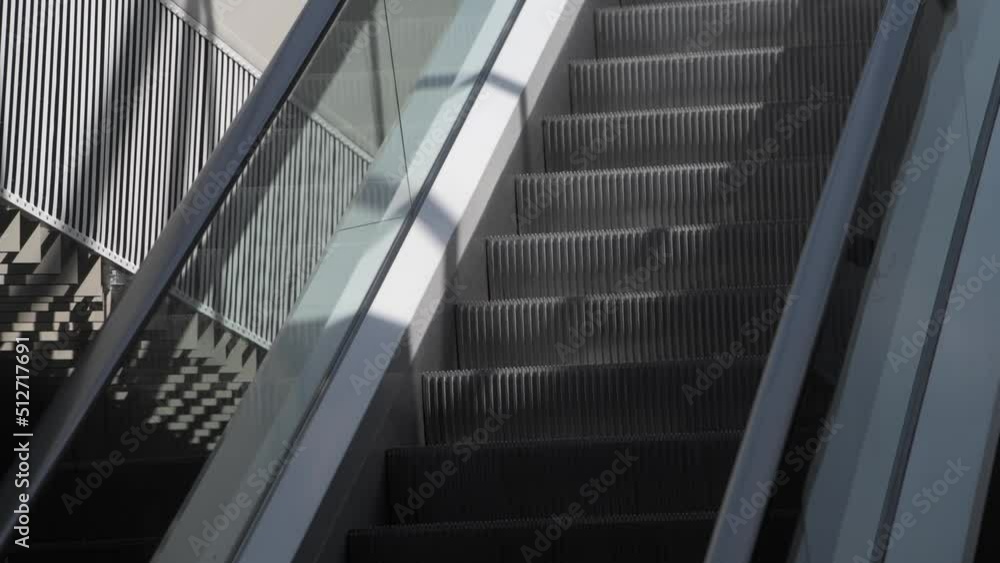 4k video with an escalator moving staircase inside a modern office building, dark grey shades color architecture 4k video with an escalator moving staircase inside a modern office building, dark grey shades color architecture