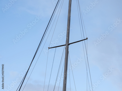 Yacht mast with ropes with blue sky in background