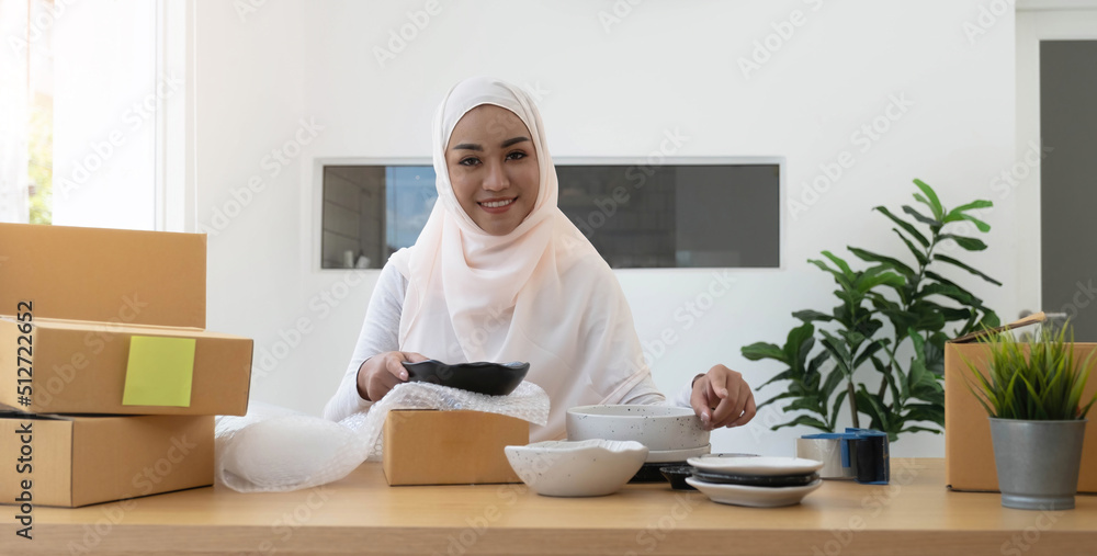 Muslim Business owner woman working online shopping prepare product packaging process at the office, young entrepreneur concept. Muslim Business owner woman working online shopping prepare product packaging process at the office, young entrepreneur concept.