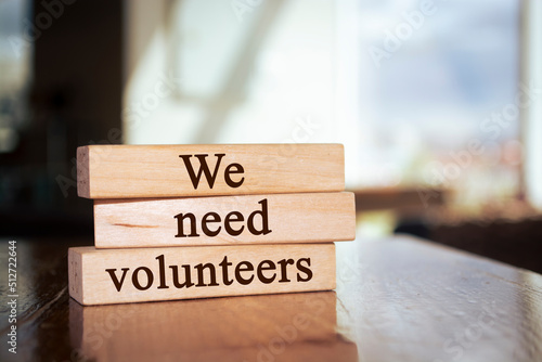 Wooden blocks with words 'We Need Volunteers'. Business concept