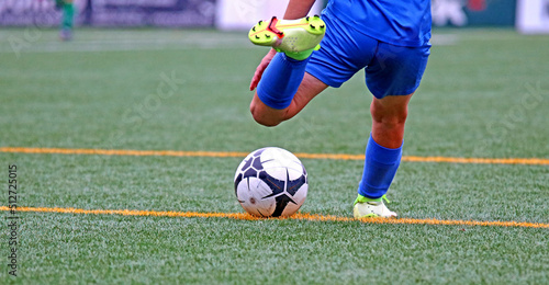 Fototapeta Naklejka Na Ścianę i Meble -  Junior soccer player kicking the ball	