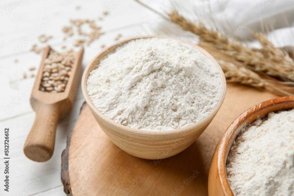 Bowl with wheat flour on wooden board Bowl with wheat flour on wooden board
