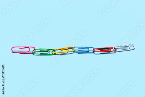Colorful paper clips on blue background