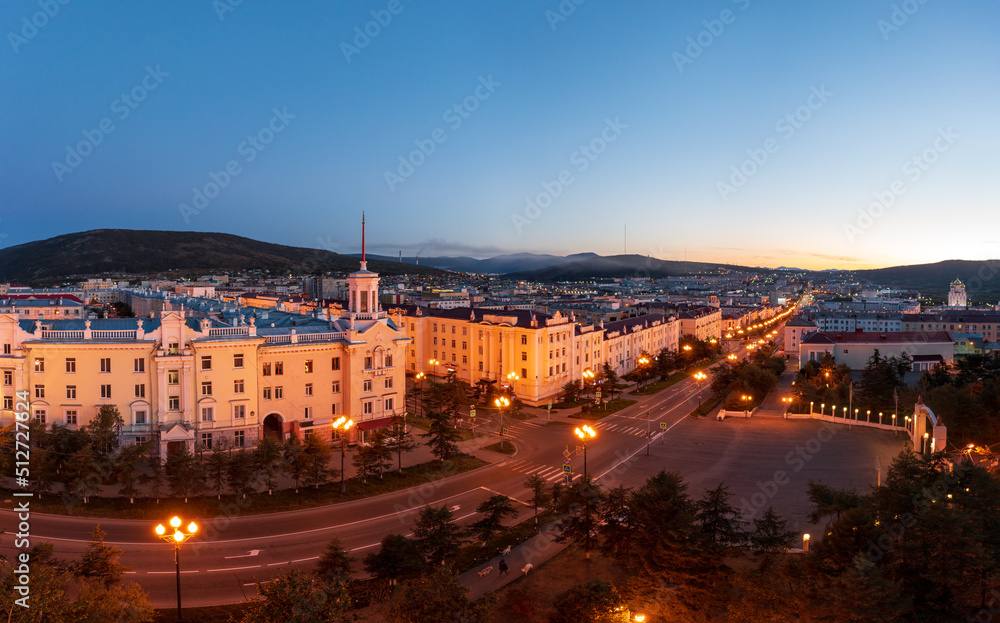 Aerial view of the city of Magadan. Top view of the streets and buildings. A beautiful tower with a spire. Historic city center. Lenin Avenue, Magadan, Far East of Russia. Morning twilight.