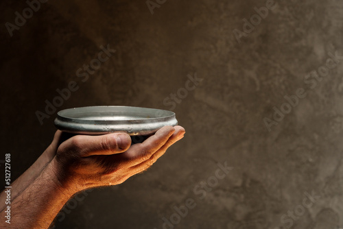 Canvas-taulu Male hands holding empty plate on dark background, lack of food, hunger concept