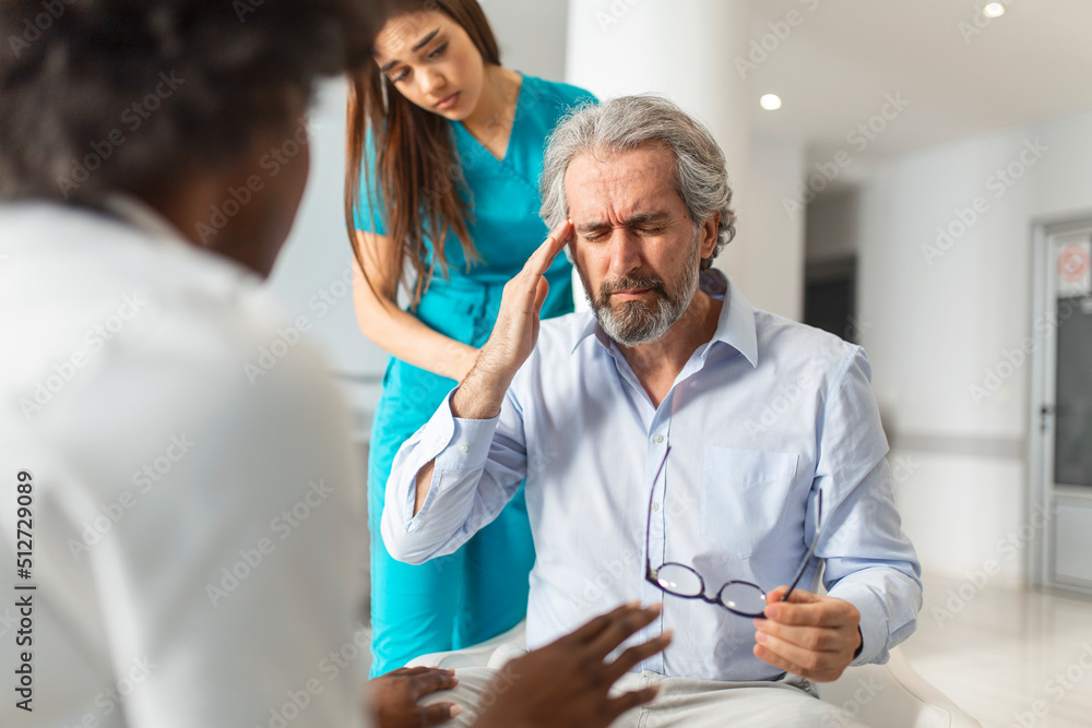 Obraz premium Female doctor reassuring supporting senior adult patient in hospital. Kind caring young woman nurse or caregiver helping older retired man talking, giving comfort, expressing care concept.