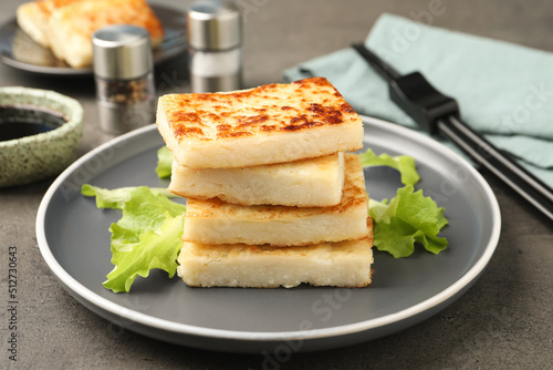 Delicious turnip cake with lettuce salad served on grey table