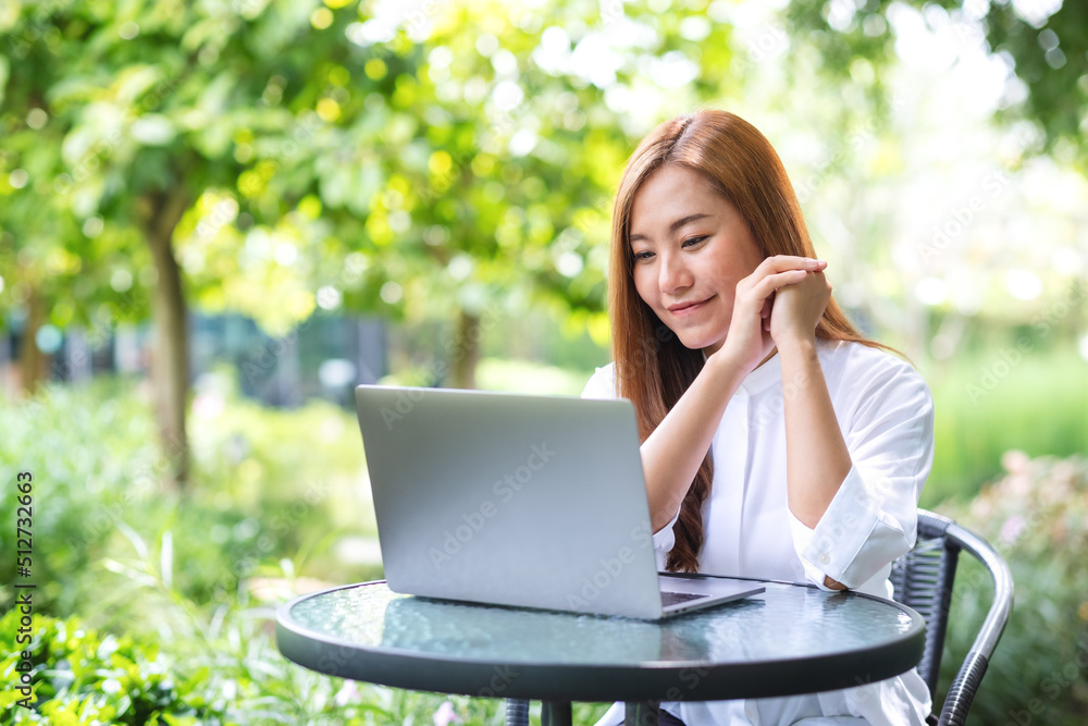 Portrait image of a businesswoman working on laptop computer in the outdoors Portrait image of a businesswoman working on laptop computer in the outdoors