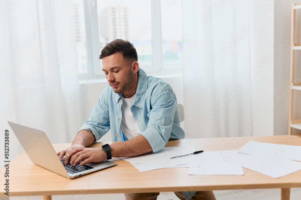 Fototapeta premium Thoughtful concentrated good-looking young businessman typing answer for clients work in call center in office. Copy space for ad. Remote Job, Technology And Career Profession Concept