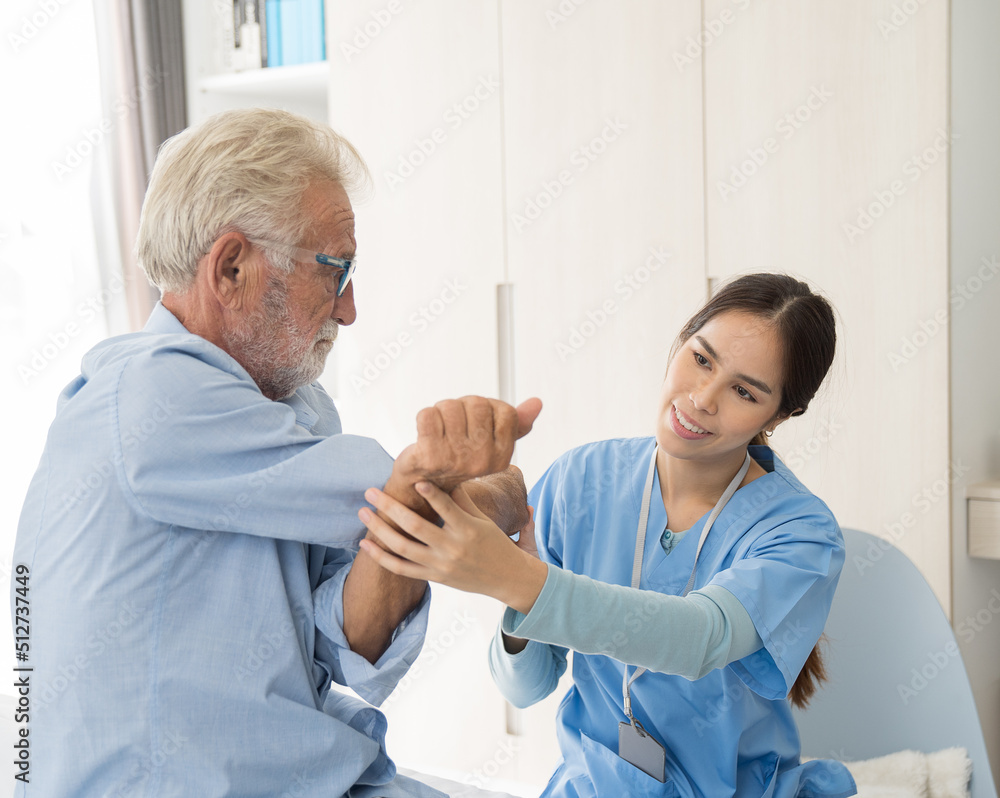 Obraz premium Woman nurse physical therapy senior man at hospital ward. Asian female nurse caring elderly man patient in room at nursing home. Hospital care and older adults concept