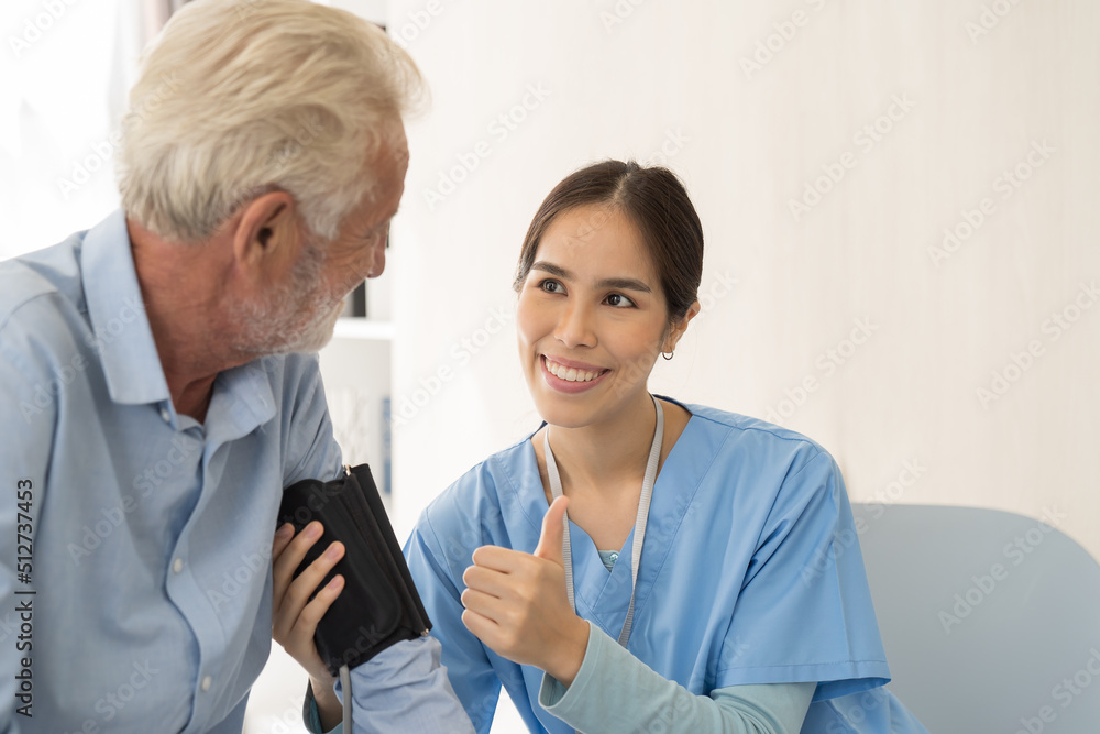 Woman nurse measure the pressure senior man at hospital ward. Asian female nurse caring elderly man patient in room at nursing home. Hospital care and older adults concept