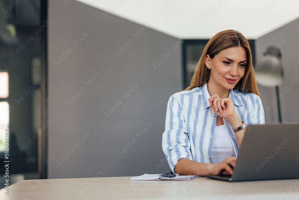 Focused businesswoman using a laptop at the office. Focused businesswoman using a laptop at the office.