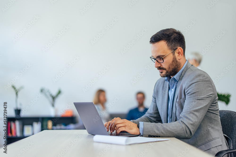 Side view of a businessman working at the office, looking focused. Side view of a businessman working at the office, looking focused.