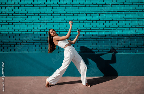 Caucasian woman dancing urban dance with daylight and a green background