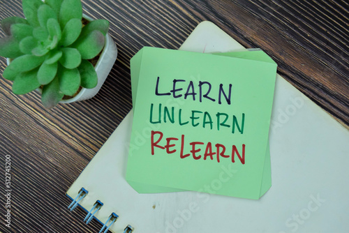 Concept of Learn, Unlearn, Relearn Continuous Learning write on sticky notes isolated on Wooden Table.