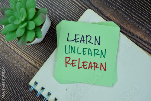 Concept of Learn, Unlearn, Relearn Continuous Learning write on sticky notes isolated on Wooden Table. photo