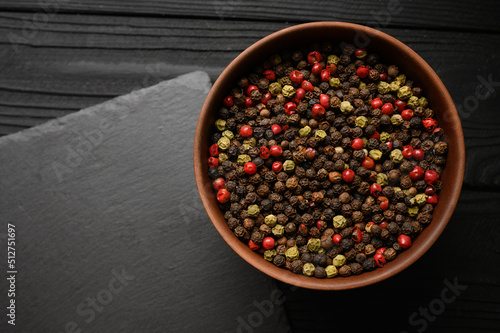 A mixture of different types of black pepper rustic backgrounds. Place for a logo.