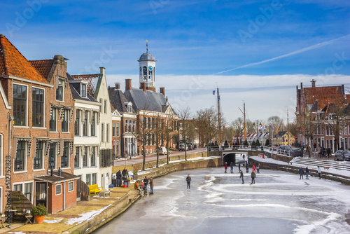 Old houses and town hall in a typical dutch winter scene in The Netherlands