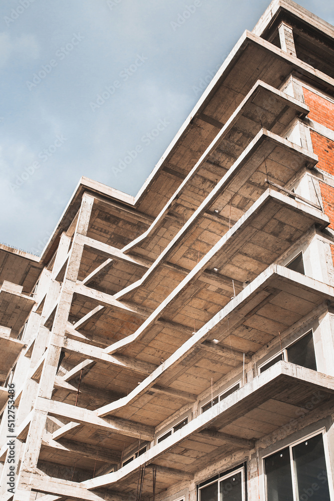 Construction site of a multi-storey building without glazing - bottom view perspective - balconies and whitewashed slabs Construction site of a multi-storey building without glazing - bottom view perspective - balconies and whitewashed slabs