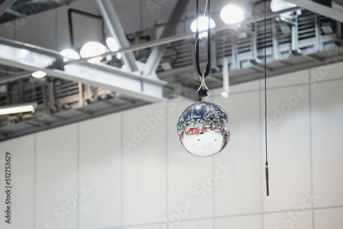 Mirror ball and microphone under the roof of the arena - attributes of the holiday