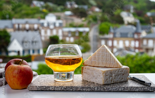 Pairing of apple cider drink with cow cheese pont l'eveque and houses of Etretat village on background, Normandy, France photo