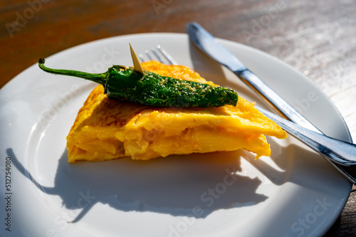 Typical snack in bars of Basque Country, pinchos or pinxtos, small slices of bread withn different toppings and fastened with skewers, San Sebastian, Spain. Potato tortilla with green pepper. photo