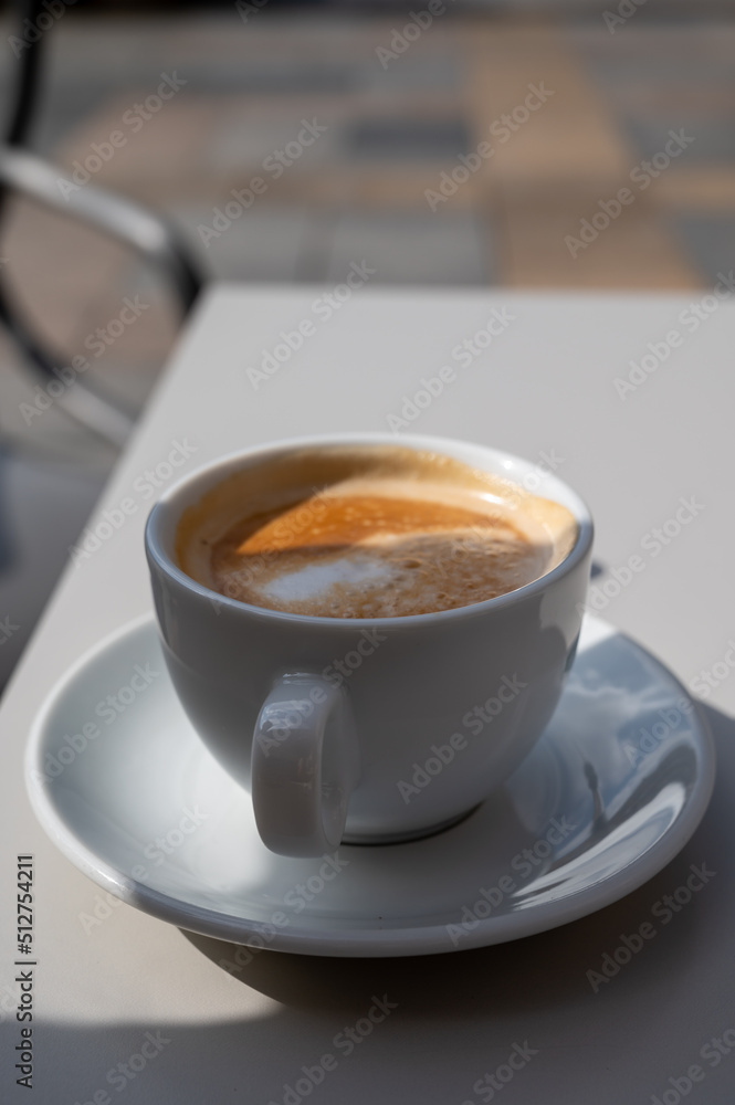 Small white cup of black arabica coffee served outdoor Small white cup of black arabica coffee served outdoor