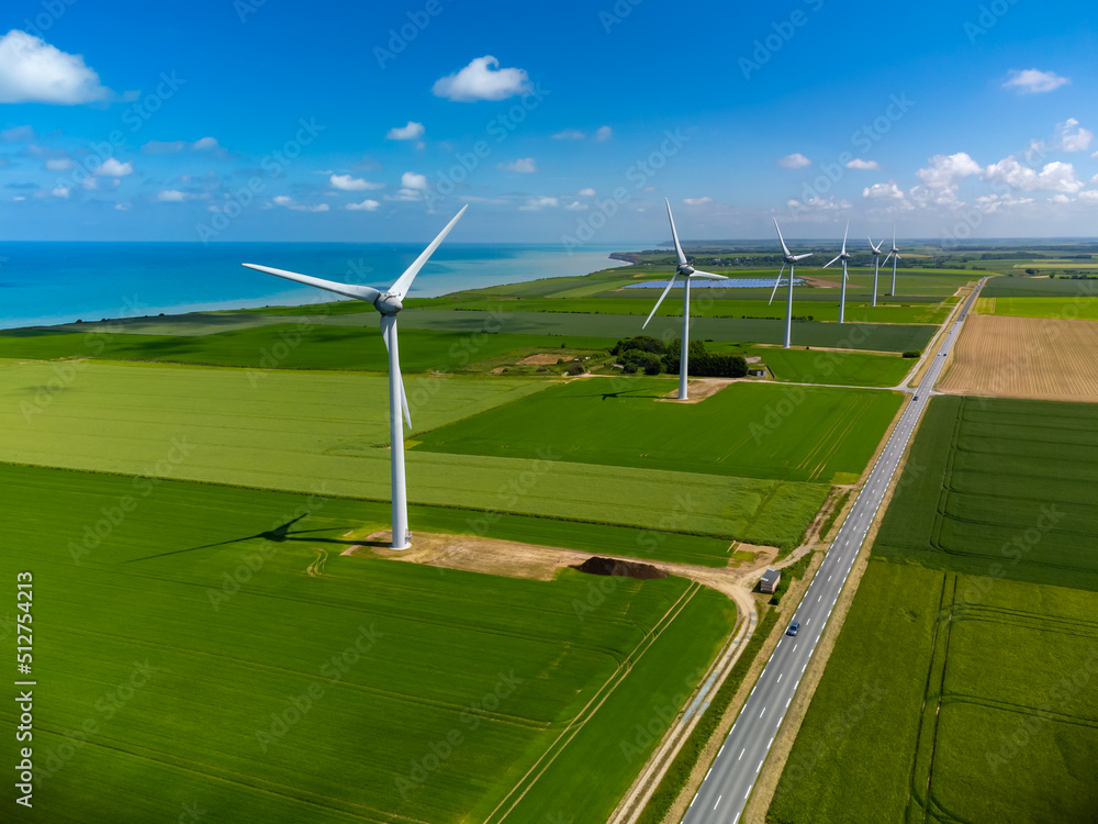 Aerial view on modern wind mills, green grain fields and blue Atlantic ocean in agricultural region Pays de Caux in Normandy, France