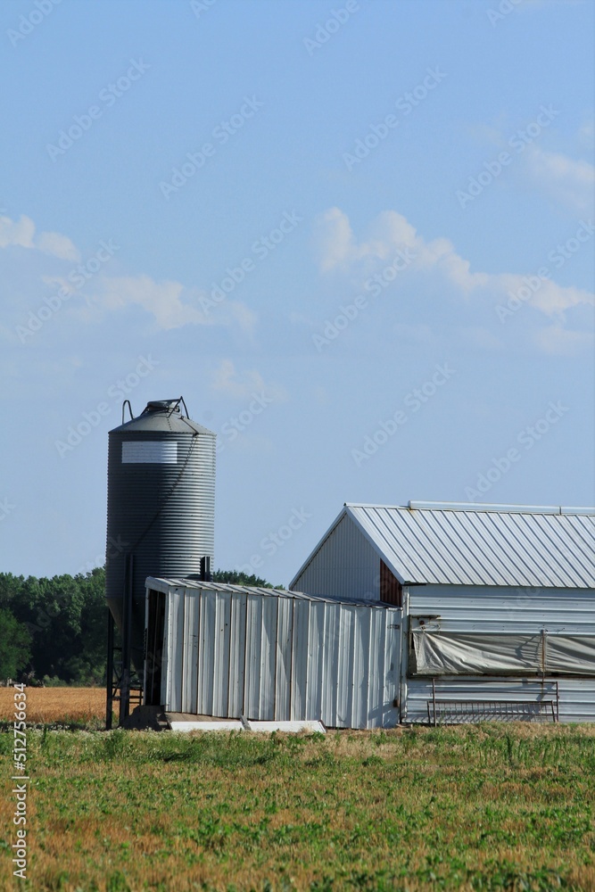 A shot of a Kansas Pig Farm by a farm field by a Corn field south of Sterling Kansas USA out in the country with clouds. A shot of a Kansas Pig Farm by a farm field by a Corn field south of Sterling Kansas USA out in the country with clouds.