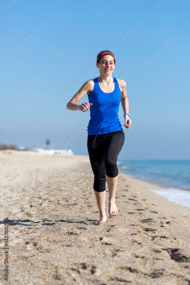 Rear view of women jogging on beach close to water