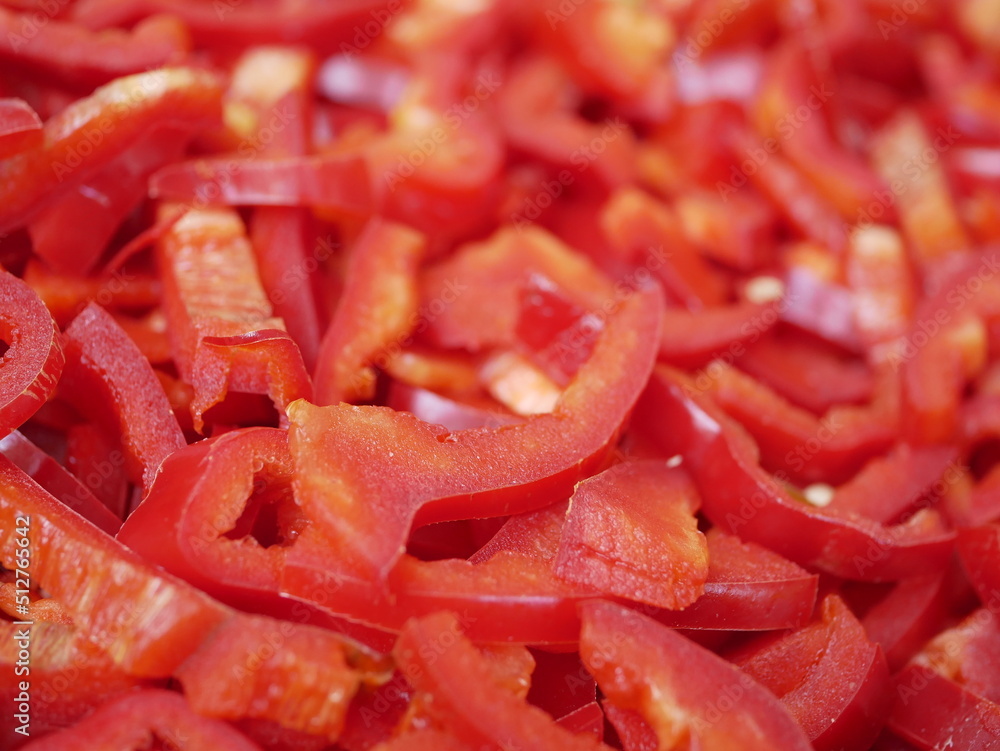 Thinly sliced red bell pepper on a plate. Fresh vegetables for salad. Natural vegetarian food, rich in vitamins. Thinly sliced red bell pepper on a plate. Fresh vegetables for salad. Natural vegetarian food, rich in vitamins.