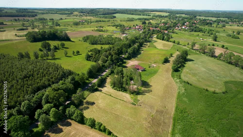 Flying over a Beautiful Rural Countryside Town in the Region of Warmian-Masurian Poland, Road Through Vast Green Lands, Wood Landscape and Local Homes Flying over a Beautiful Rural Countryside Town in the Region of Warmian-Masurian Poland, Road Through Vast Green Lands, Wood Landscape and Local Homes