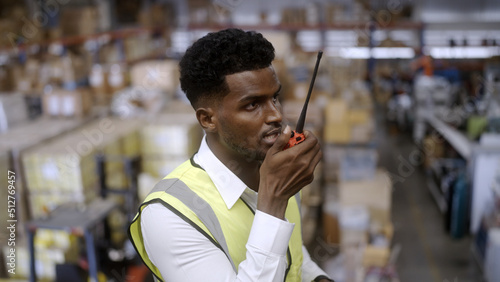 Black worker is checking the goods in the warehouse.