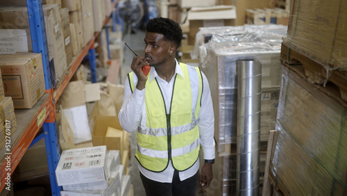 Black worker is checking the goods in the warehouse.