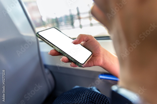 Woman uses smartphone with blank frameless screen on the train - template for mobile applications