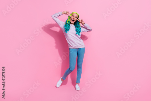 Full length picture of energetic cheery girl showing v-sign say hello meet friends isolated on pink color background © deagreez